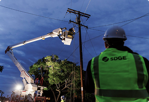 Technicians performing urgent repairs on a power transmission line after dusk